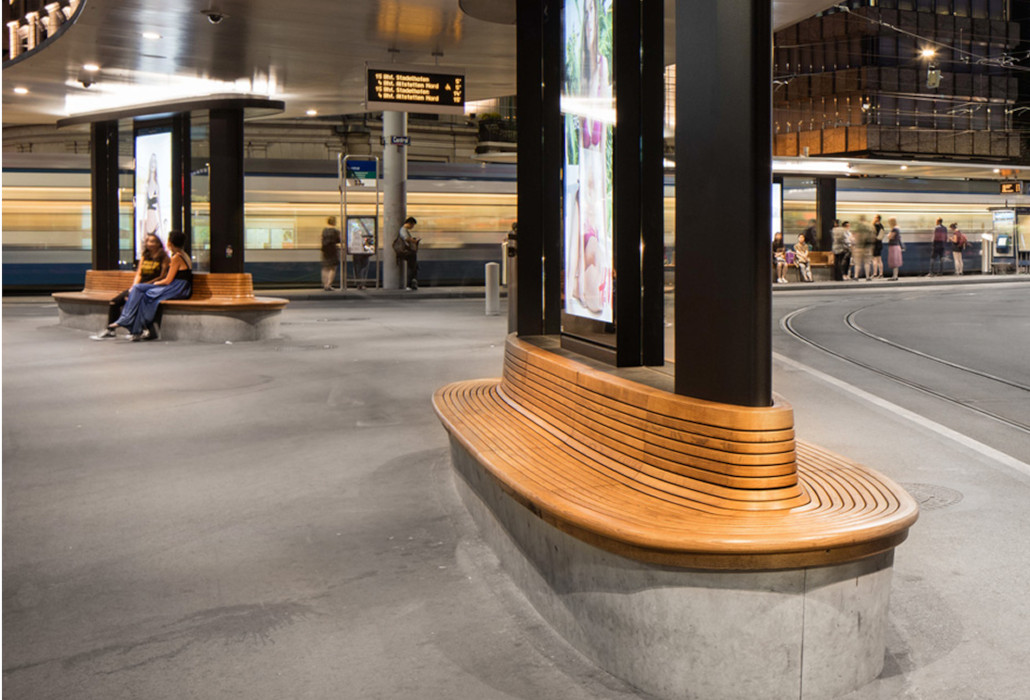 Curved wooden bench with backrest at a public bus stop